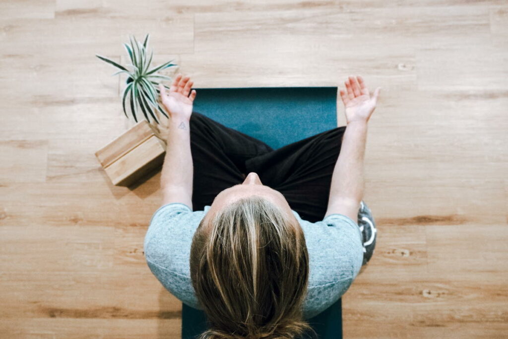 Bird's eye shot of blonde woman meditating on floor