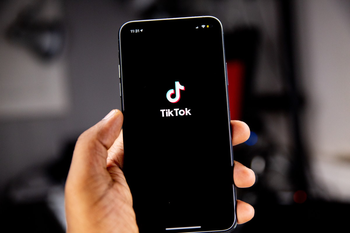 Hand holding smartphone that has the TikTok app open
