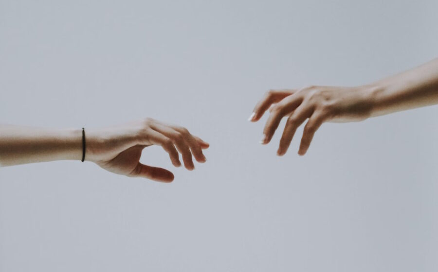 Two hands reaching out towards one another