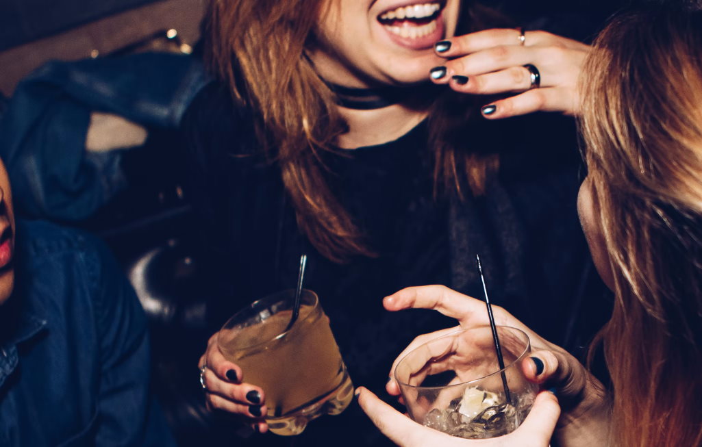 Close up of two women at a party holding drinks