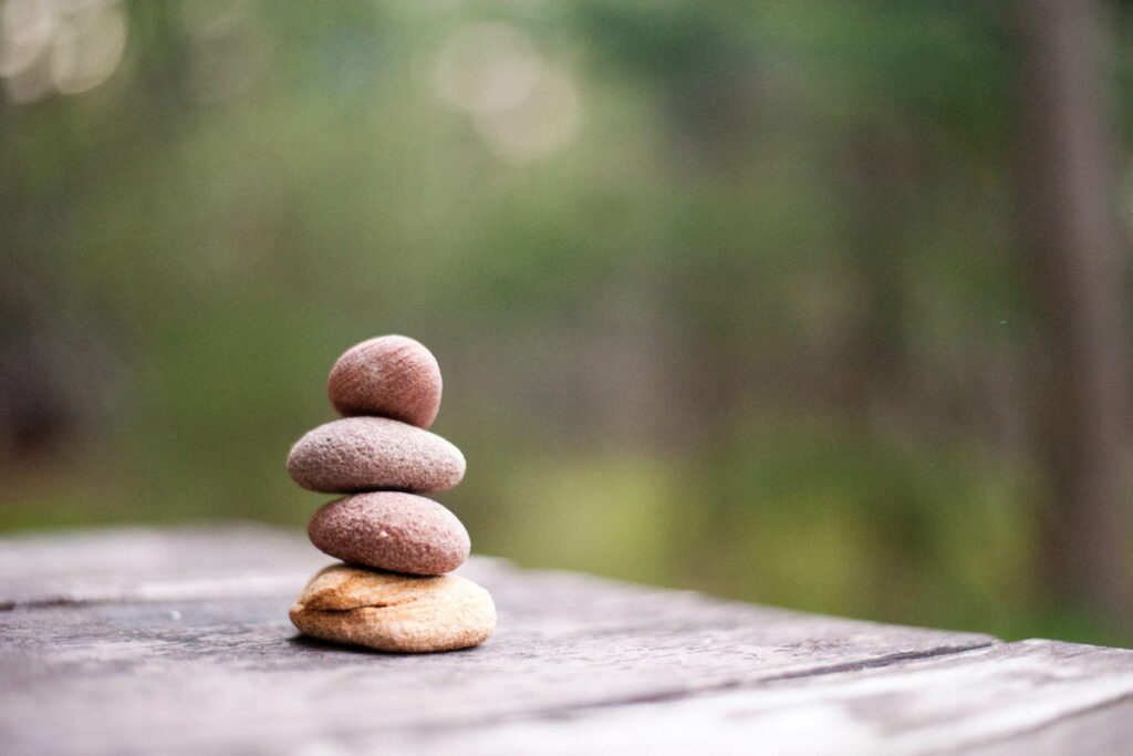 A balanced stack of pebbles on a table with a blurred background
