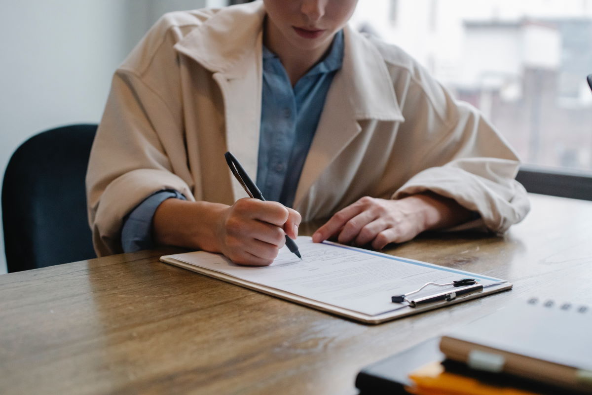 A woman seated at a table filling out a questionnaire
