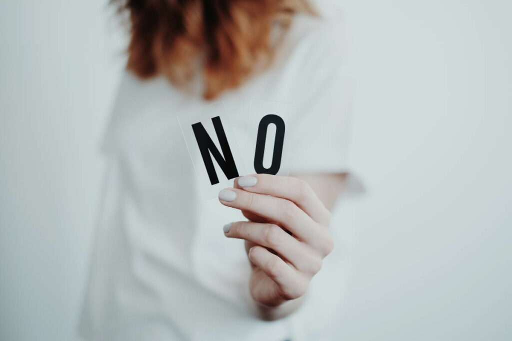 Out of shot woman holding up letters that spell out the word 'no'
