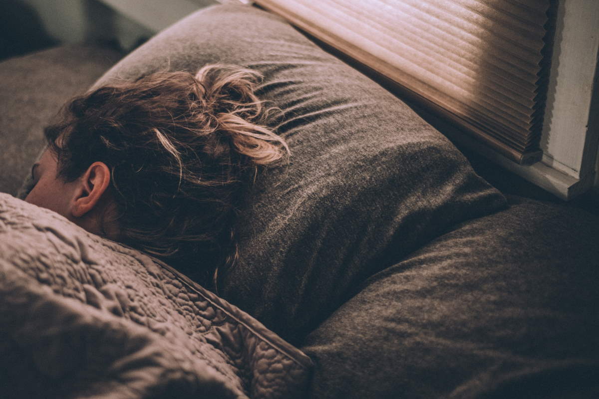 Woman lying in bed under a quilt